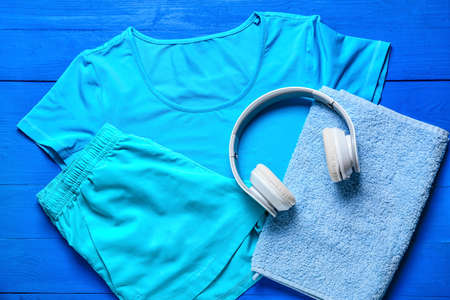 Sportswear and headphones on color wooden backgroundの写真素材