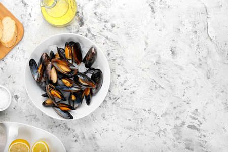 Bowl with tasty mussels on light backgroundの写真素材