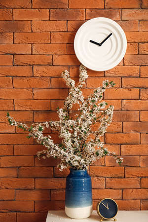 Vase with beautiful blossoming branches on table in roomの写真素材