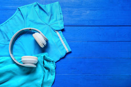 Sportswear and headphones on color wooden backgroundの写真素材