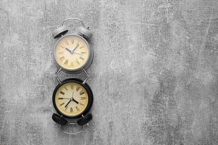 Two old style alarm clocks on textured gray backgroundの写真素材