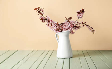 Vase with beautiful blossoming branches on color wooden backgroundの写真素材