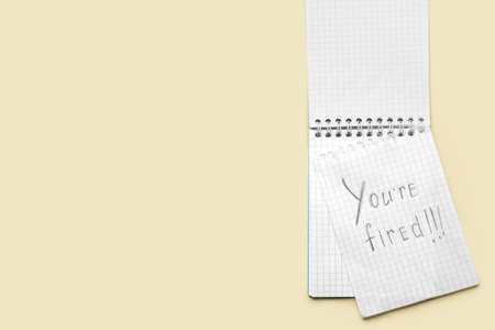 Notebook with text YOU'RE FIRED on color background. Concept of dismissalの写真素材
