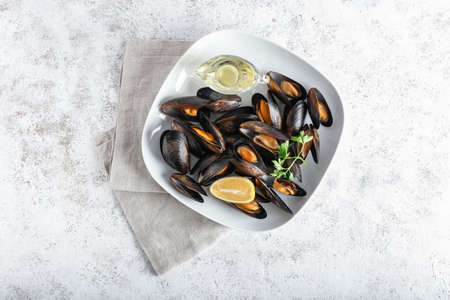 Tasty mussels with lemon on light background