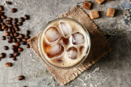 Glass of tasty iced coffee on grunge background