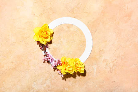 Beautiful daffodils and blank frame on color background