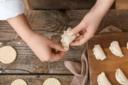 Woman preparing tasty dumplings on kitchen table, closeupの写真素材