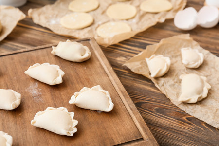 Board with raw dumplings on wooden background, closeupの写真素材