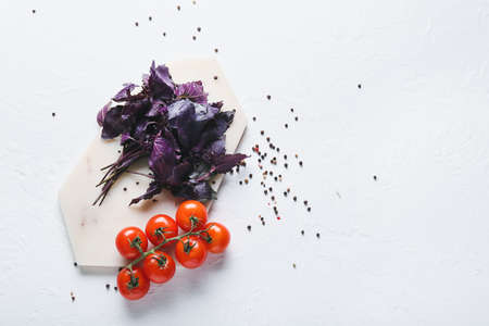 Fresh basil, tomatoes and peppercorns on light backgroundの写真素材