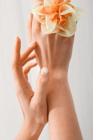 Woman with beautiful manicure and flower on light backgroundの写真素材