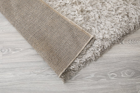 Soft carpet on wooden floor, closeup