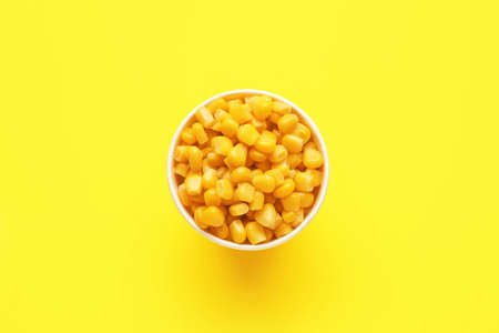 Bowl of corn kernels on color backgroundの写真素材