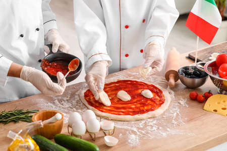 Italian chefs making tasty pizza in kitchen, closeupの写真素材