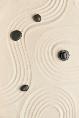 Black spa stones on light sand