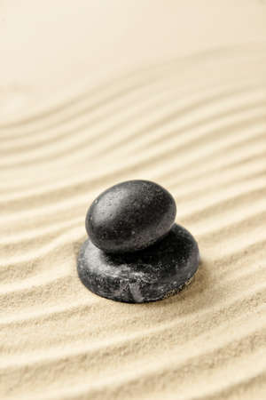 Black spa stones on light sandの写真素材