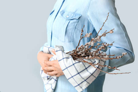 Beautiful woman with willow branches on light backgroundの写真素材