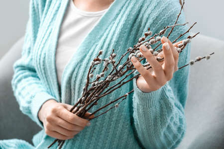 Beautiful woman with willow branches at home, closeupの写真素材