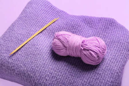 Yarn with knitting needles and plaid on color background, closeupの写真素材
