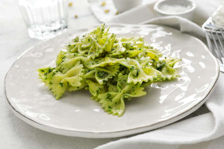 Plate with tasty pesto pasta on table