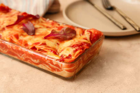 Baking dish with tasty tomato lasagna on light backgroundの写真素材