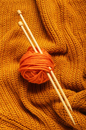 Yarn with knitting needles on fabric backgroundの写真素材