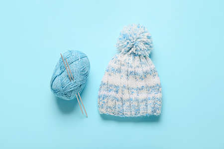 Yarn with knitting needles and hat on color backgroundの写真素材