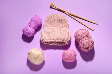 Knitting yarn, needles and hat on color backgroundの写真素材