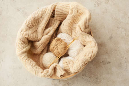Basket with yarn and knitting needles on tableの写真素材