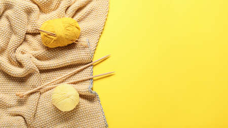 Yarn with knitting needles and plaid on color backgroundの写真素材