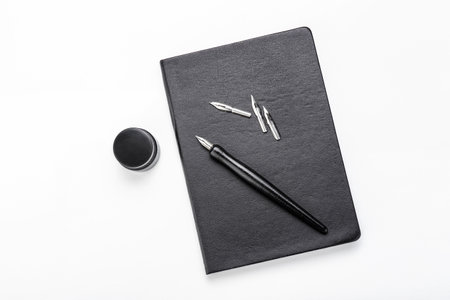 Nib pen with ink and notebook on white backgroundの写真素材