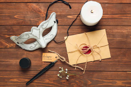 Envelope with text LAVENDER LAVANDULA, carnival mask and nib pen on dark wooden background