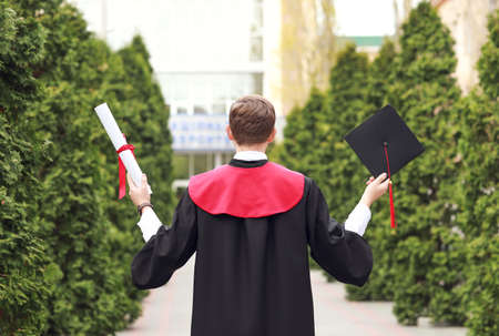 Male graduating student outdoors, back view