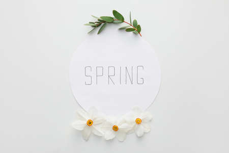 Paper sheet with word SPRING and beautiful daffodils on light backgroundの写真素材