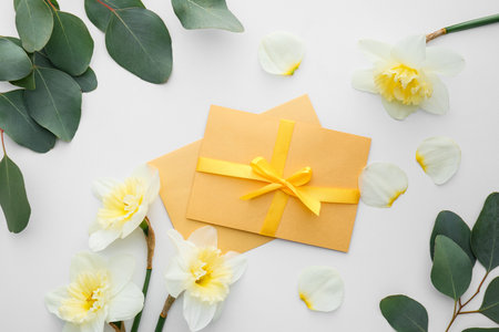 Beautiful daffodils and greeting cards on white background