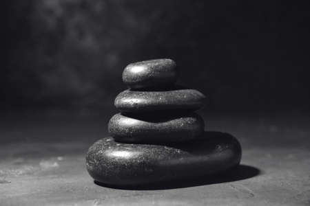 Stack of black zen stones on dark backgroundの写真素材