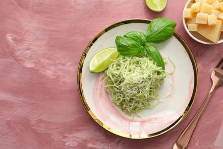 Plate with tasty pesto pasta and lime on color backgroundの写真素材
