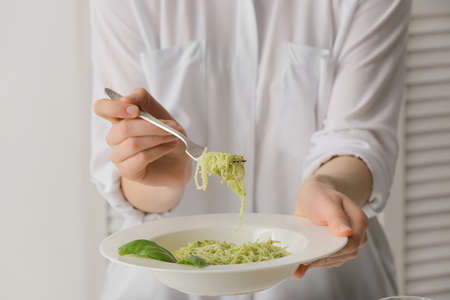 Woman eating tasty pesto pasta, closeupの写真素材