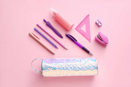 Pencil case with stationery on color background