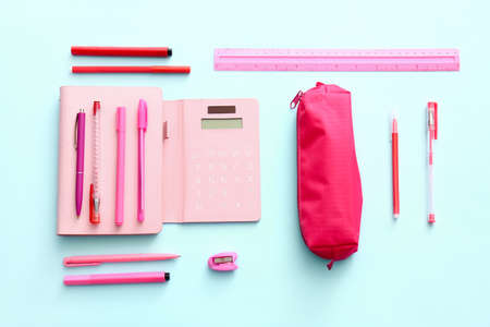 Pencil case with stationery on color background