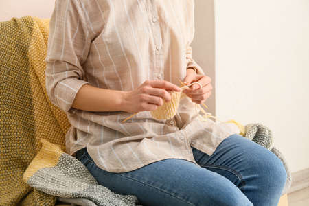 Young woman knitting at home