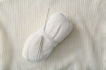 Knitting yarn and needles on fabric backgroundの写真素材