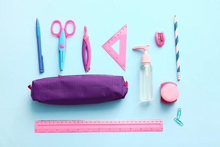 Pencil case with stationery on color background