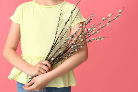 Little girl with willow branches on color backgroundの写真素材