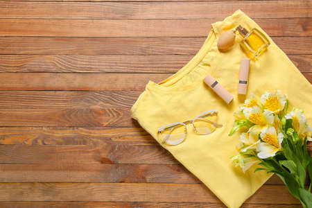 Composition with t-shirt, sunglasses, cosmetics and flowers on wooden backgroundの写真素材