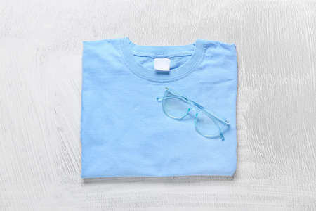 Stylish t-shirt and eyeglasses on light backgroundの写真素材