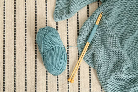Knitting yarn, needles and plaid on carpet