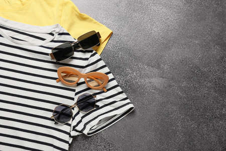 Stylish t-shirts and sunglasses on dark backgroundの写真素材