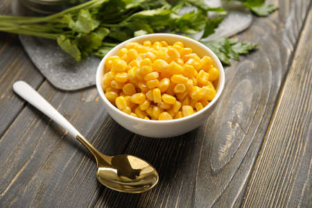 Bowl with corn kernels on wooden background, closeupの写真素材