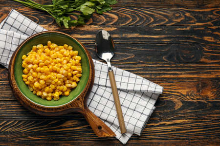 Bowl with corn kernels on wooden backgroundの写真素材