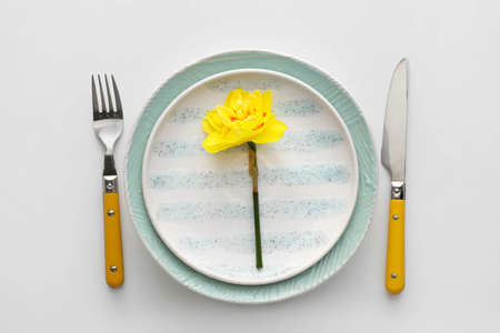 Beautiful table setting with narcissus flower on white backgroundの写真素材